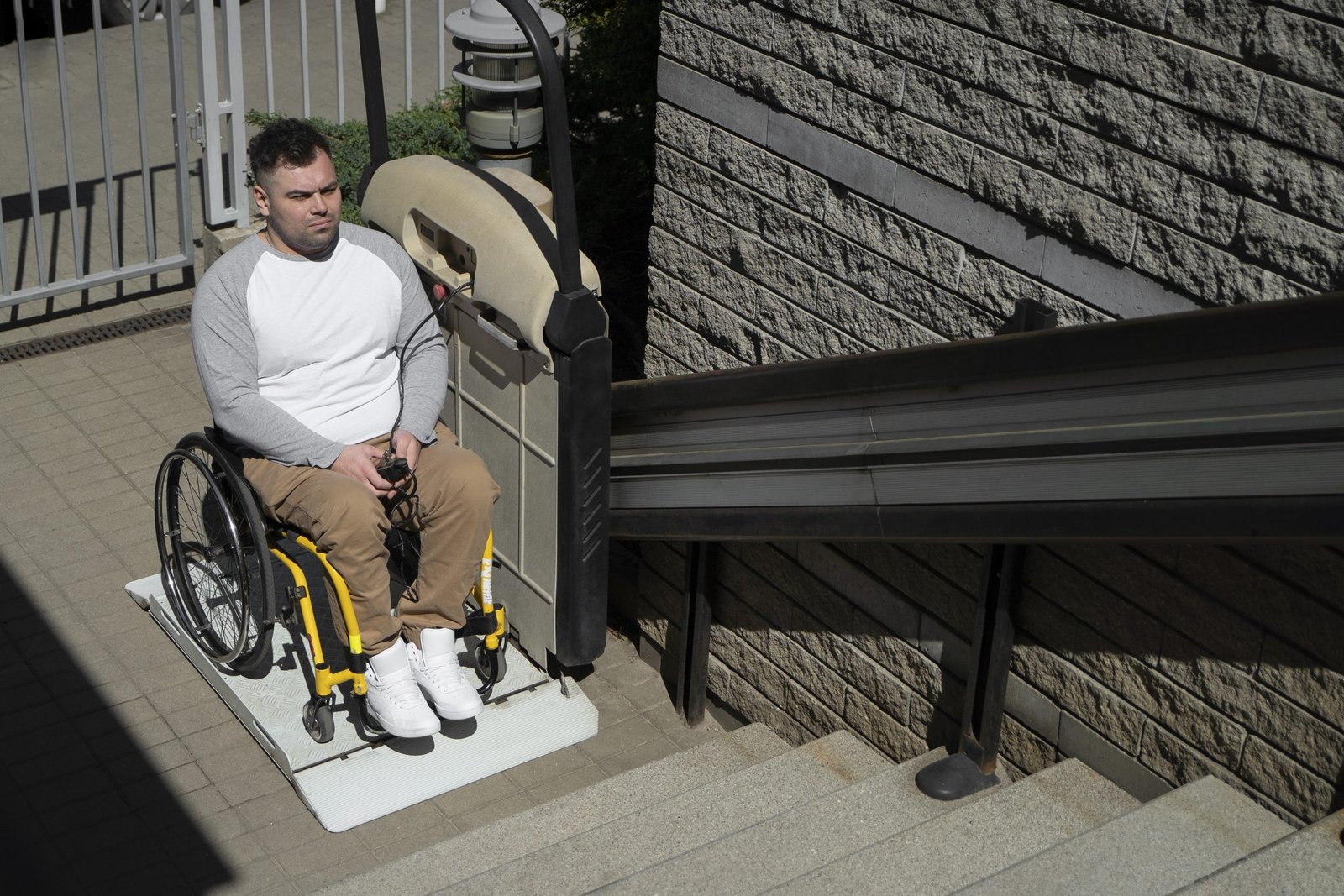 A person using a wheelchair outdoors with a support worker